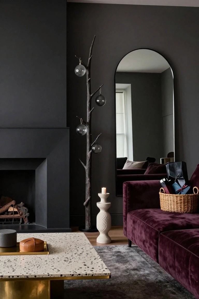 Living room featuring dark gray walls, black fireplace with fire, purple velvet sofa, gold-edged coffee table with tray, tall black branch sculpture with hanging glass ornaments, arched black mirror, and wrapped gifts in a wicker basket.