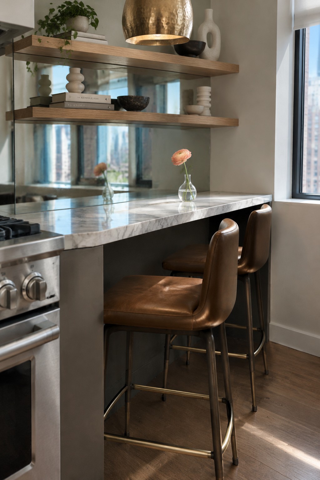 Two brown upholstered stools sit at a marble kitchen island beneath floating wooden shelves.